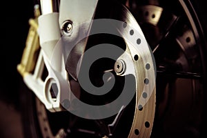 Background of front brake disc of motorcycle close up