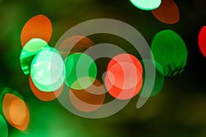 Background full of unfocused colored lights. Blurred traces of lights and spots of Christmas tree