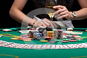 Background of a gaming casino, poker table, cards, chips and a girl with a glass of wine in the background. Background for a