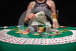 Background of a gaming casino, poker table, cards, chips and a girl with a glass of wine in the background. Background for a