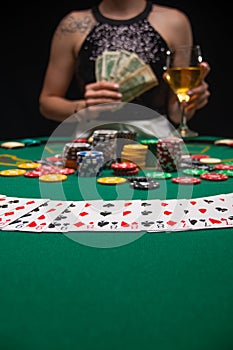 Background of a gaming casino, poker tables, cards, chips and a girl with a glass of wine. Background for a gaming business,