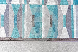Background graphic, top view of a geometric rug with blue and grey color patterns, on top of a beige carpet, as a design element
