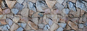 Background of gray and brown cobblestones, uneven stones close up
