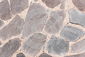 Background of gray stone surface texture. Old road made of natural stone. Top view, horizontal