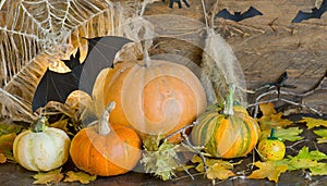 Background with halloween pumpkins, candles and autumn leaves on the wooden house porch