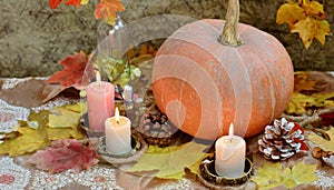 Background with halloween pumpkins, candles and autumn leaves on the wooden house porch