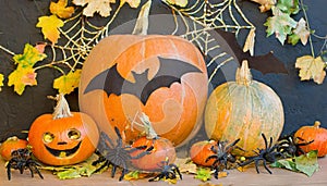 Background with halloween pumpkins, candles and autumn leaves on the wooden house porch