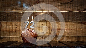 Background happy birthday pie or muffin with candles burning digit number 72. Festive card Happy Birthday on the background of