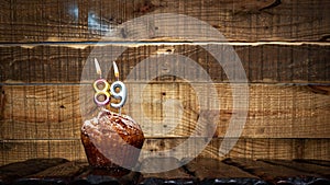 Background happy birthday pie or muffin with candles burning digit number 89. Festive card Happy Birthday on the background of