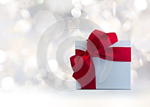 background hoilday blurry white lights circles background with light blue gift box with red ribbon