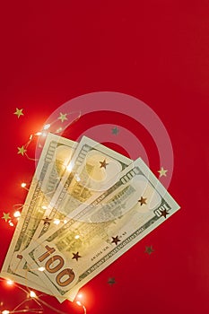 Background for holiday card with money US dollars. Background of one hundred dollar bills. Banknotes, paper currency on red