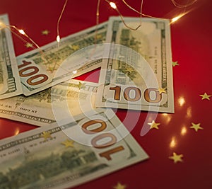 Background for holiday card with money US dollars. Background of one hundred dollar bills. Banknotes, paper currency on red