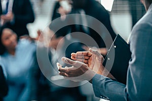 Background image of a business woman standing in the office applauding.