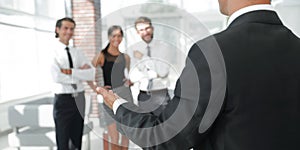 Background image of businessman holding out hand for a handshake.