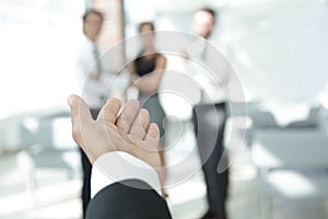 Background image of businessman holding out hand for a handshake.