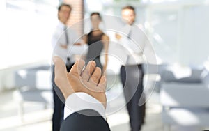 Background image of businessman holding out hand for a handshake.