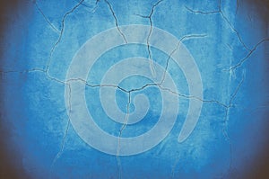 Background image of destructive cracks on a blue wall