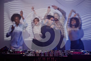 Background image of DJ music station at retro disco party with people dancing