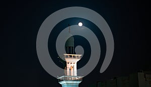 Background image of mosque minaret during full moon night