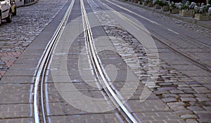 Background. Image of an old street with gray stone paving of the road and metal rails.