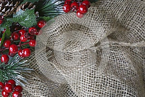 Background image of rough burlap framed with ornamental cranberries
