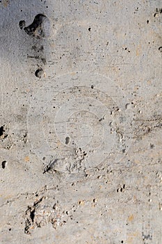 Background image of a rough concrete pour. Modern finishing of concrete walls. Holes  dents  scratches