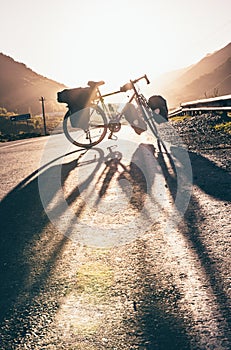 Background image of standing touring bicycle without cyclist on the road with nocars. Cycling in a countryside. Kazkbegi national