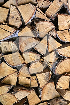 Background image of woodpile. Firewood is neatly stacked. Birch logs