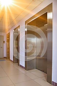 Background of interior floor of elevator platform with elevators and sunlight in business center