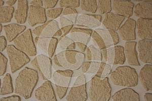 Texture of irregular beige shaped stones on the wall. photo
