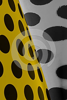 A background of large black dots on yellow paper.