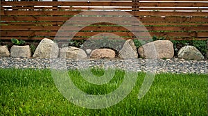 Background of lawn paths made of stones and a wooden fence