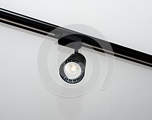 Background Led track lamp on the ceiling in the interior. Interior spotlight in black color. Modern track lamp with many rotary