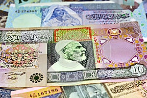 Background of Libyan money dinars banknotes with portraits of Omar Al-Mukhtar and Muammar Gaddafi on some banknotes