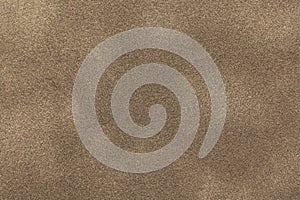 Background of light bronze suede fabric closeup. Velvet matt texture of sand nubuck textile