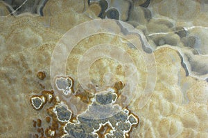 Background from a light natural stone Onyx with bubbles and gray stains on the surface is called onix naranja veteado photo