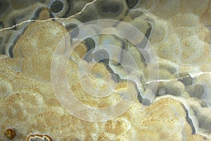 Background from a light natural stone Onyx with bubbles and gray stains on the surface, onix naranja veteado