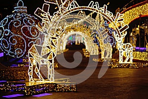 Background of light tunnel with deers and Christmas balls with defocused lights