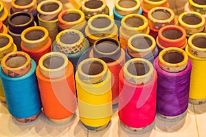 Background with a lot of colorful coils with threads. Bobbins ar