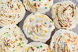 Background lot of cupcakes with cream and colored sugar sprinkle