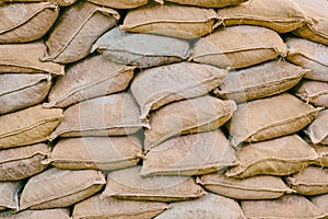 Background of lying dirty sandbags. Bags to strengthen the defensive structure during the battle. Sandbag flood protection wall