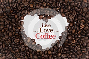 Background made of coffee beans in a heart shape with message `Live Love Coffee`