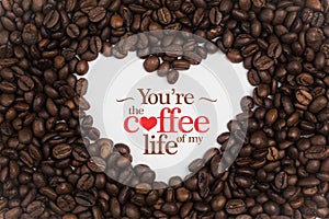 Background made of coffee beans in a heart shape with message `You`re the coffee of my life`