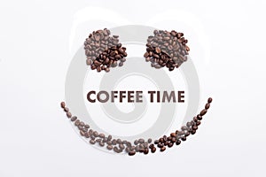 Background made of coffee beans in a smiley face shape with message `Coffee time`
