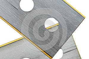 Background made from a macro photo of pile of razor blades with yellow blades, isolated on a white background, top view.