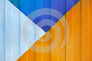 Background made of metal profile painted in blue, yellow and white on the fence or container backlit