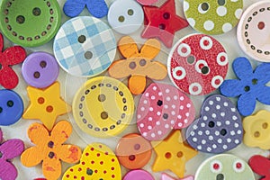 The background is made up of multicolored buttons of different sizes and shapes.