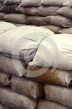 Background of many dirty sand bags for flood defense. Protective sandbag barricade for military use. Handsome tactical bunker