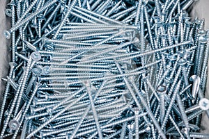 background of many metal screws. A pattern of construction parts