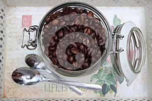 Background with many small coffee beans in the jar photo